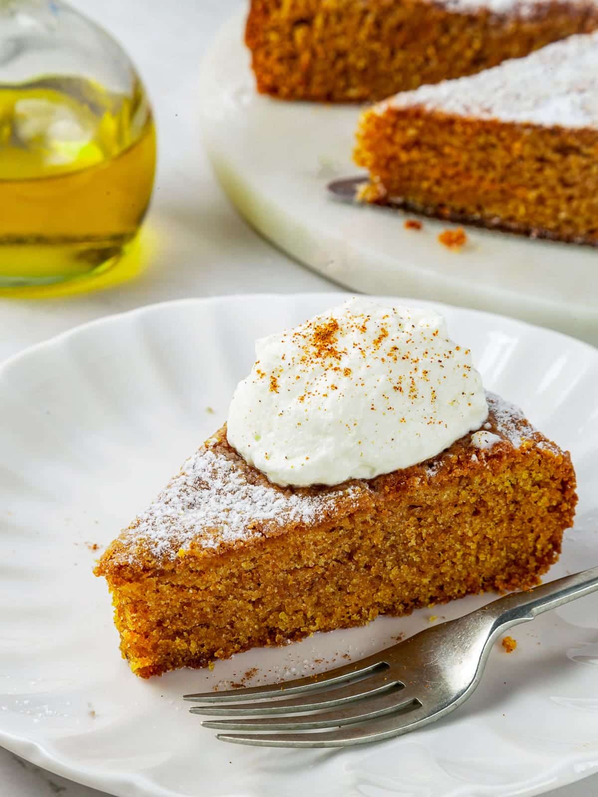 One generous piece of spiced pumpkin cake resting on a plate with fork nearby.