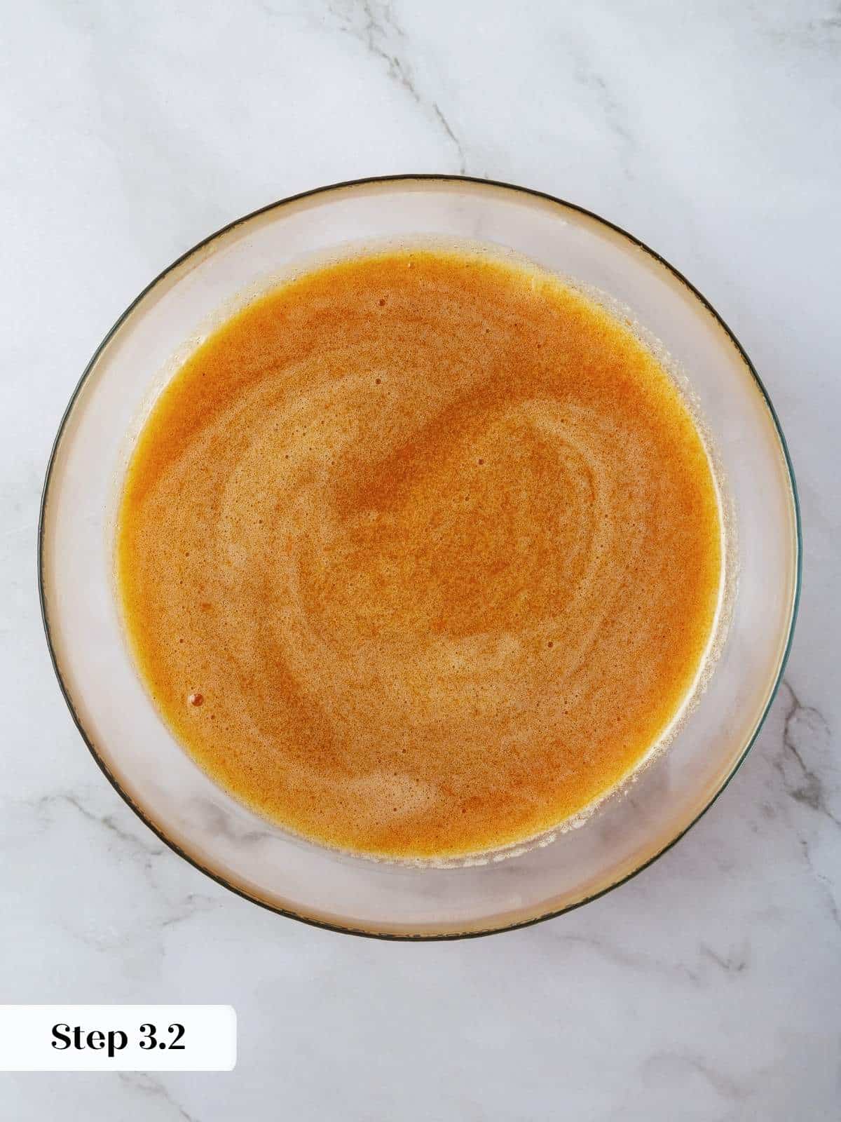 Wet ingredients are fully emulsified in a mixing bowl, creating a silky pumpkin base.