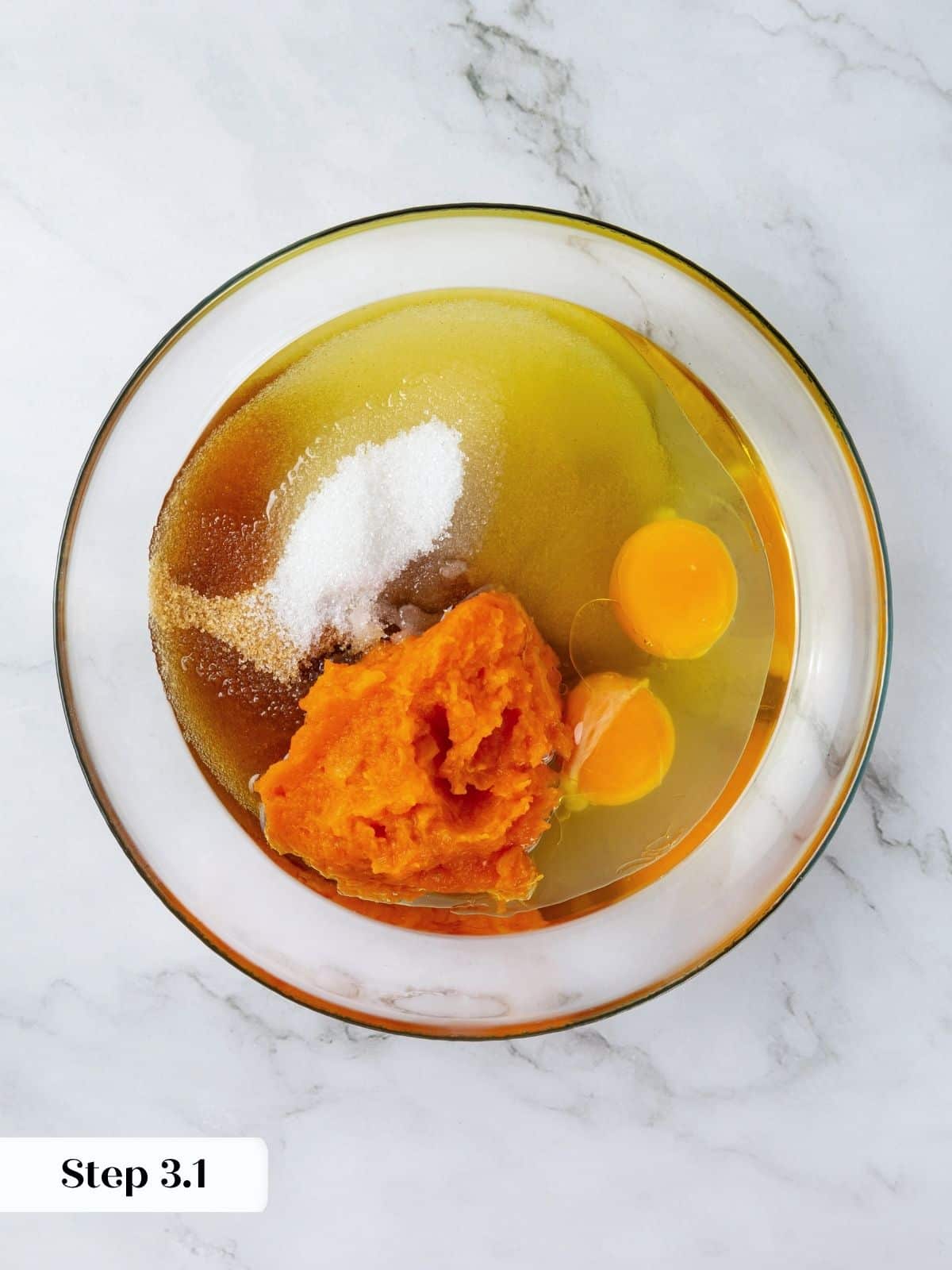Olive oil, pumpkin, sugar, and eggs just added to a mixing bowl before whisking together.