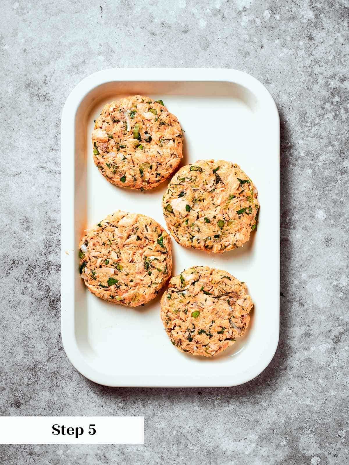Formed salmon burger patties arranged on tray, prepped for chilling or cooking.