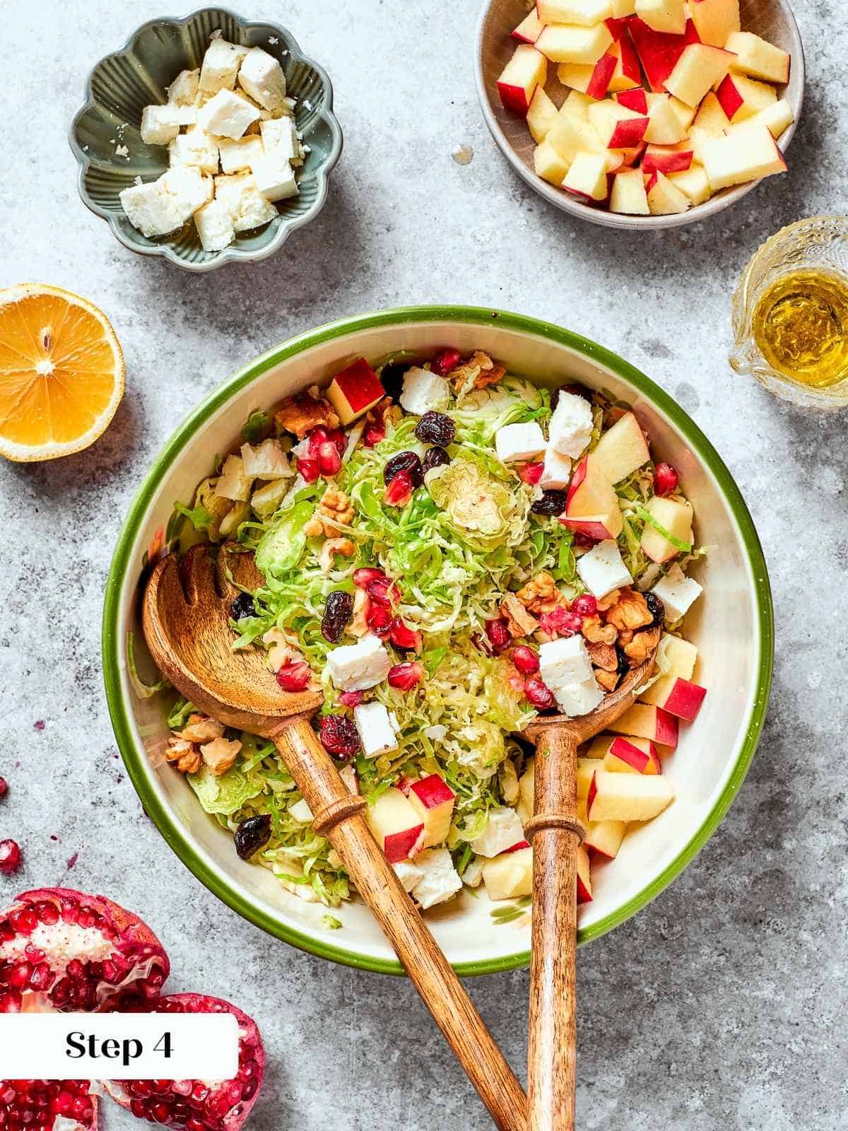 Pears, feta, and dried fruit added to the Brussels sprouts base in a large bowl.