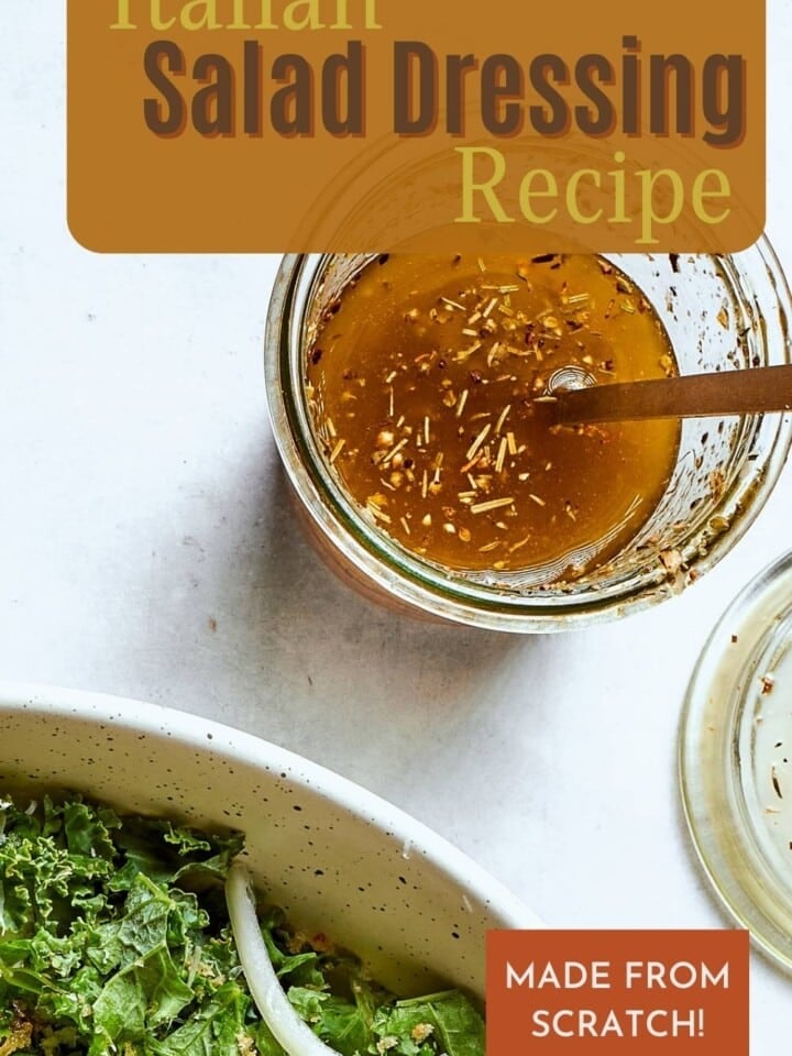 Vibrant Italian salad dressing mixed with a spoon with herbs, garlic powder, and parmesan cheese.