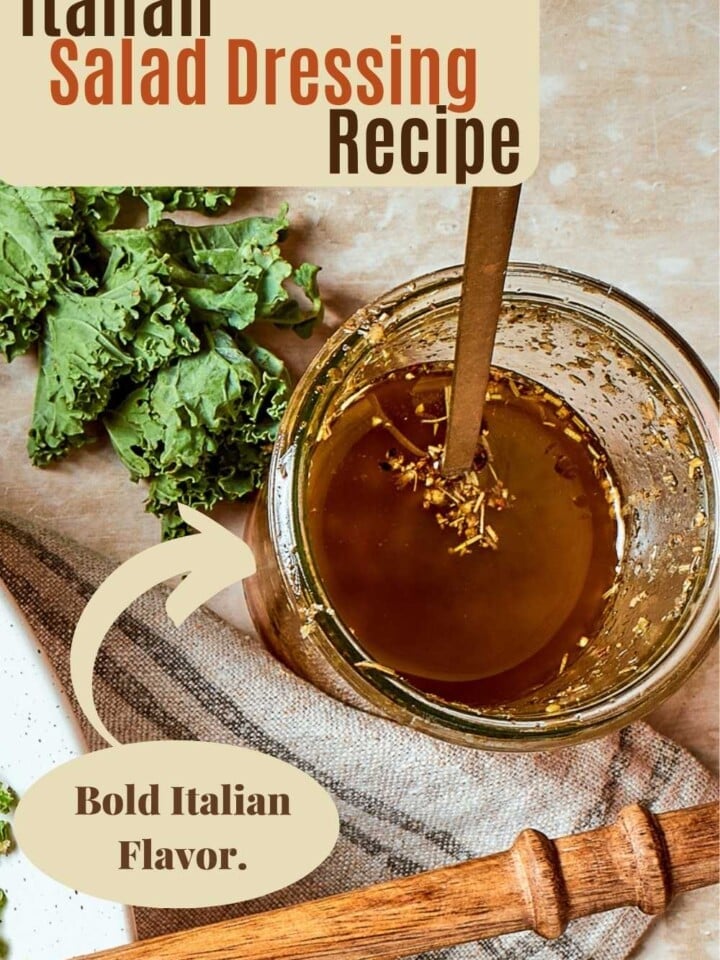 Fresh Italian salad dressing with visible herbs and parmesan in a clear mixing jar.