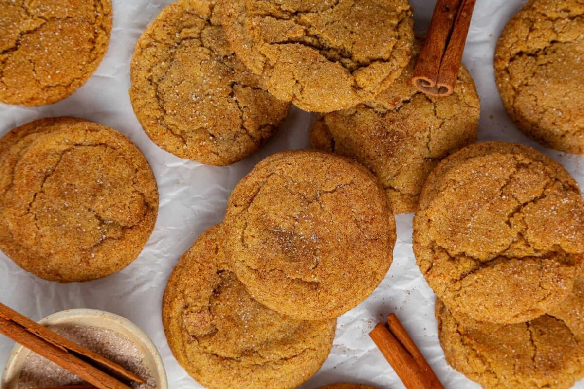 Pumpkin snickerdoodle cookies with crackled tops and sugar coating, highlighting chewy texture and spiced flavor.