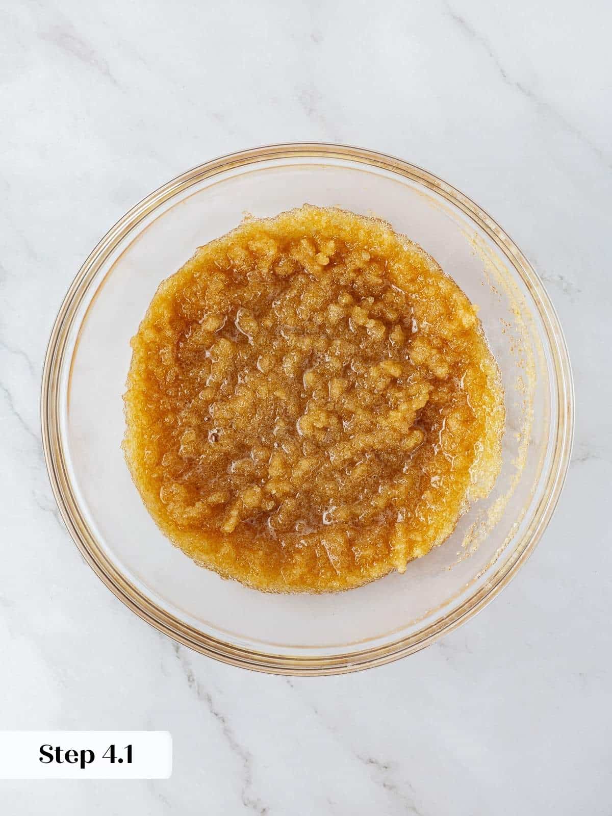 Mixing browned butter with sugars in a bowl for pumpkin snickerdoodle cookie dough.