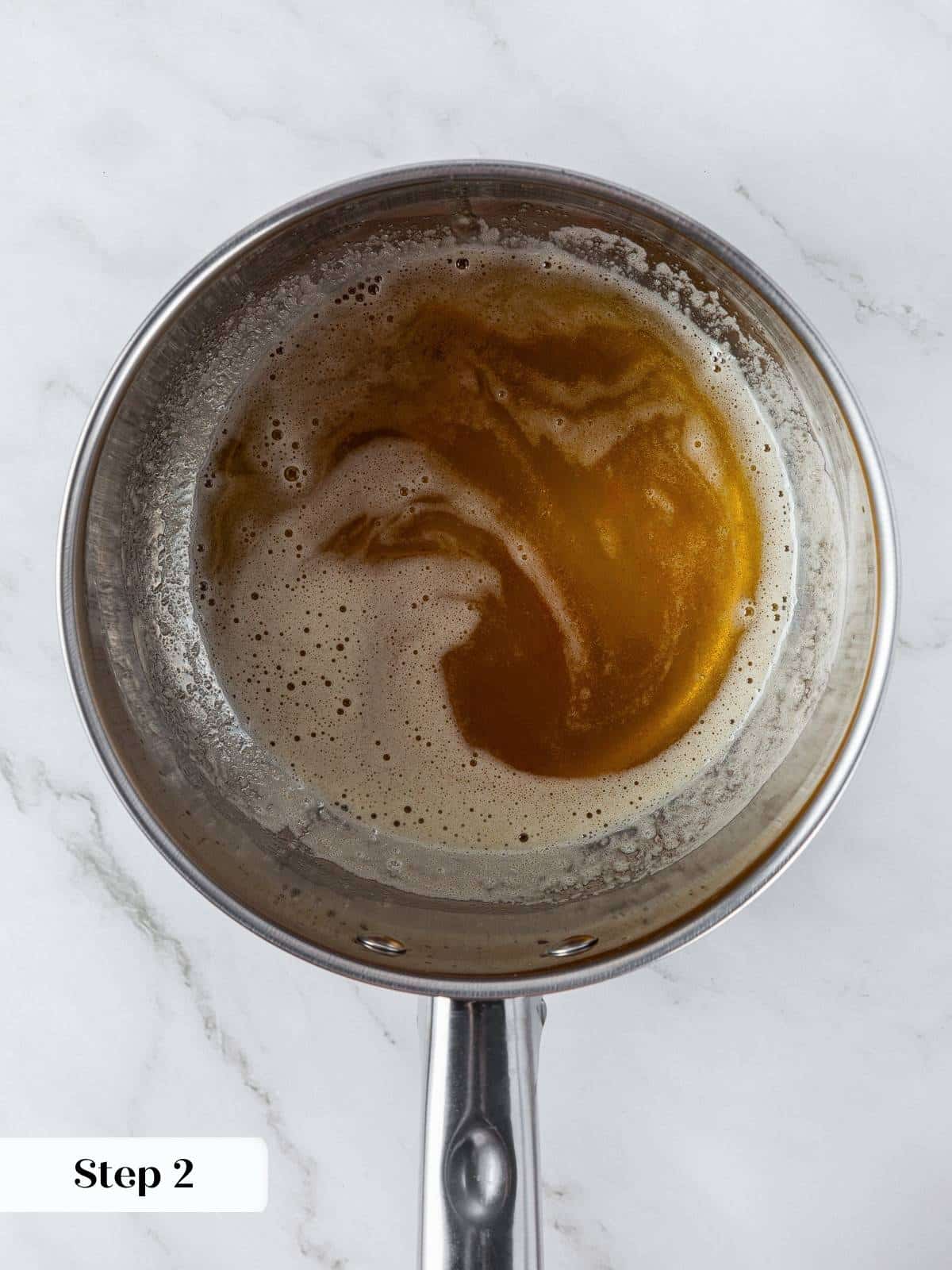 Saucepan of browned butter for pumpkin snickerdoodles, showing golden color and nutty aroma stage.