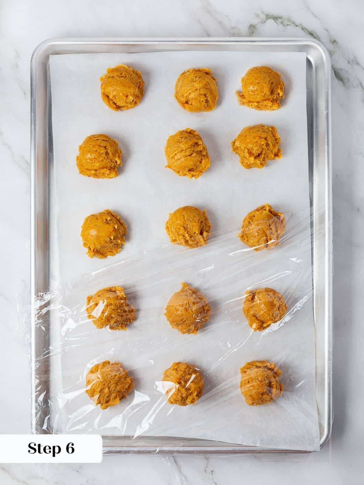 Scooped pumpkin snickerdoodle cookie dough on parchment paper before chilling.