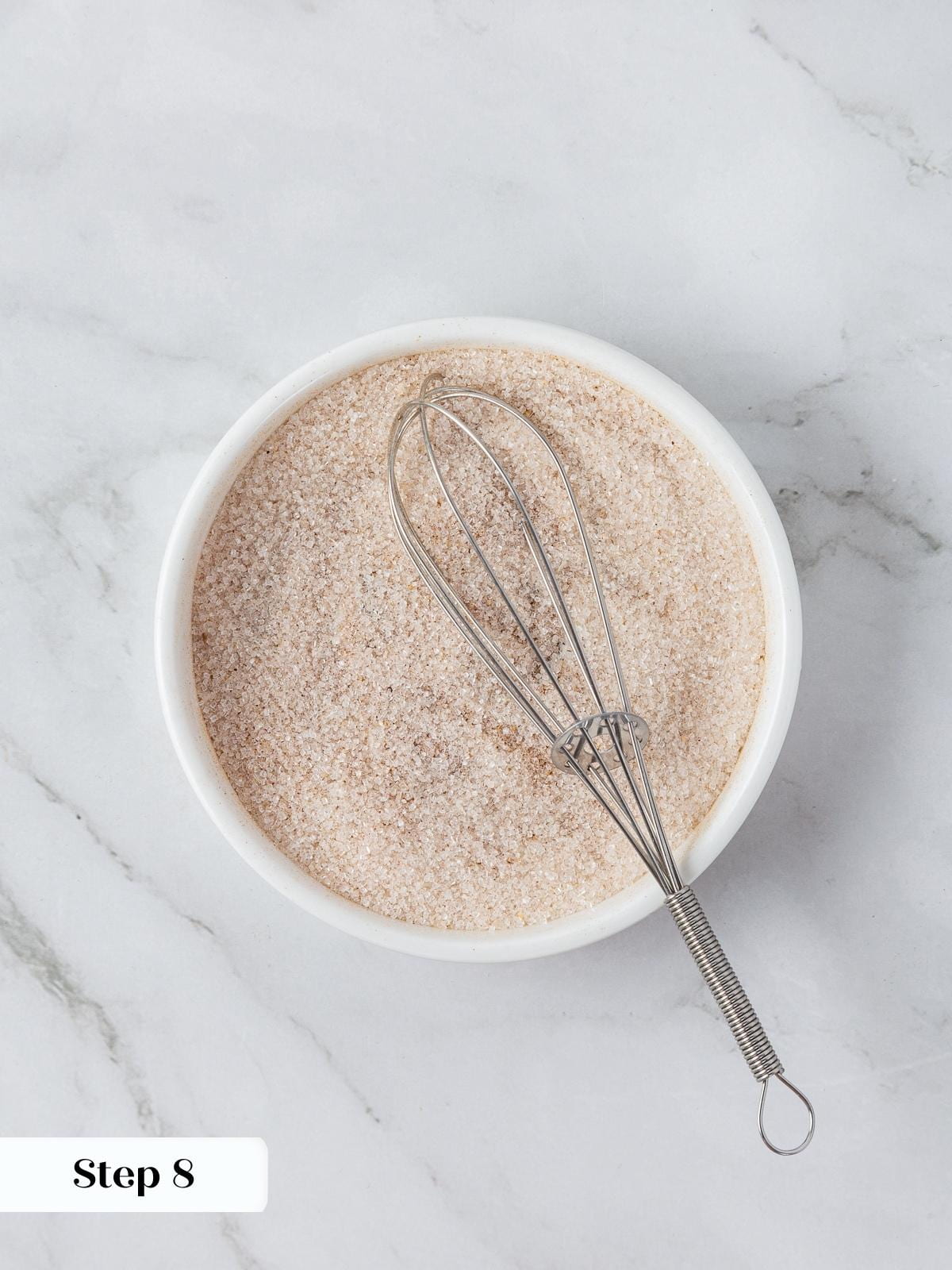 Small bowl of sugar and pumpkin spice mixed for coating snickerdoodle cookies.