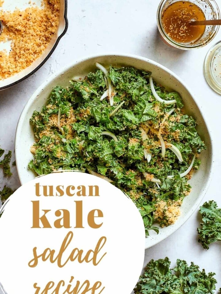 Tuscan kale salad with parmesan, onions, and crunchy breadcrumbs served in a large bowl.