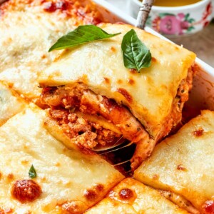 Melted mozzarella stretching as a slice of zucchini lasagna is pulled from the pan.