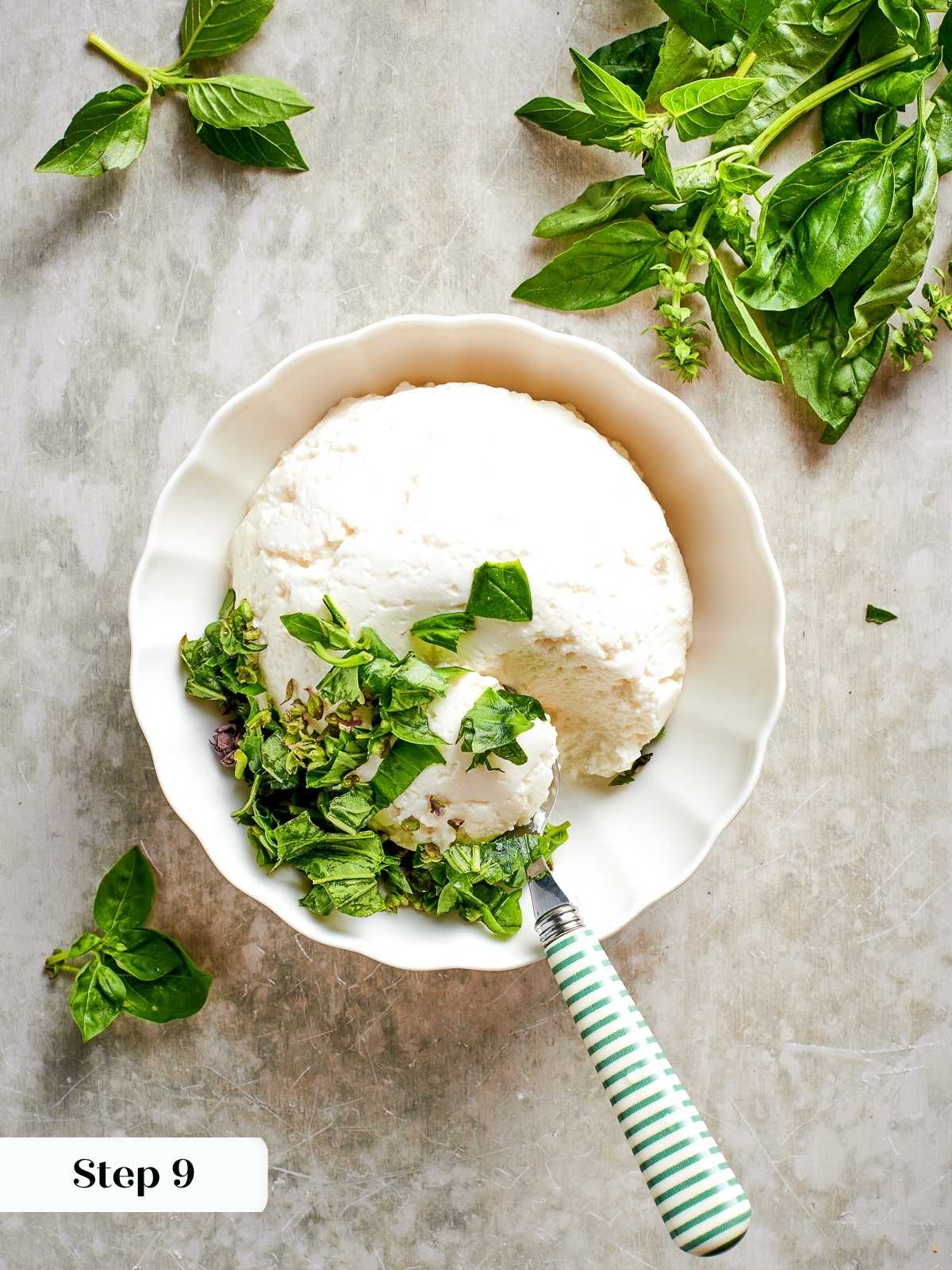 Ricotta cheese being mixed with herbs in a small bowl for the lasagna filling.