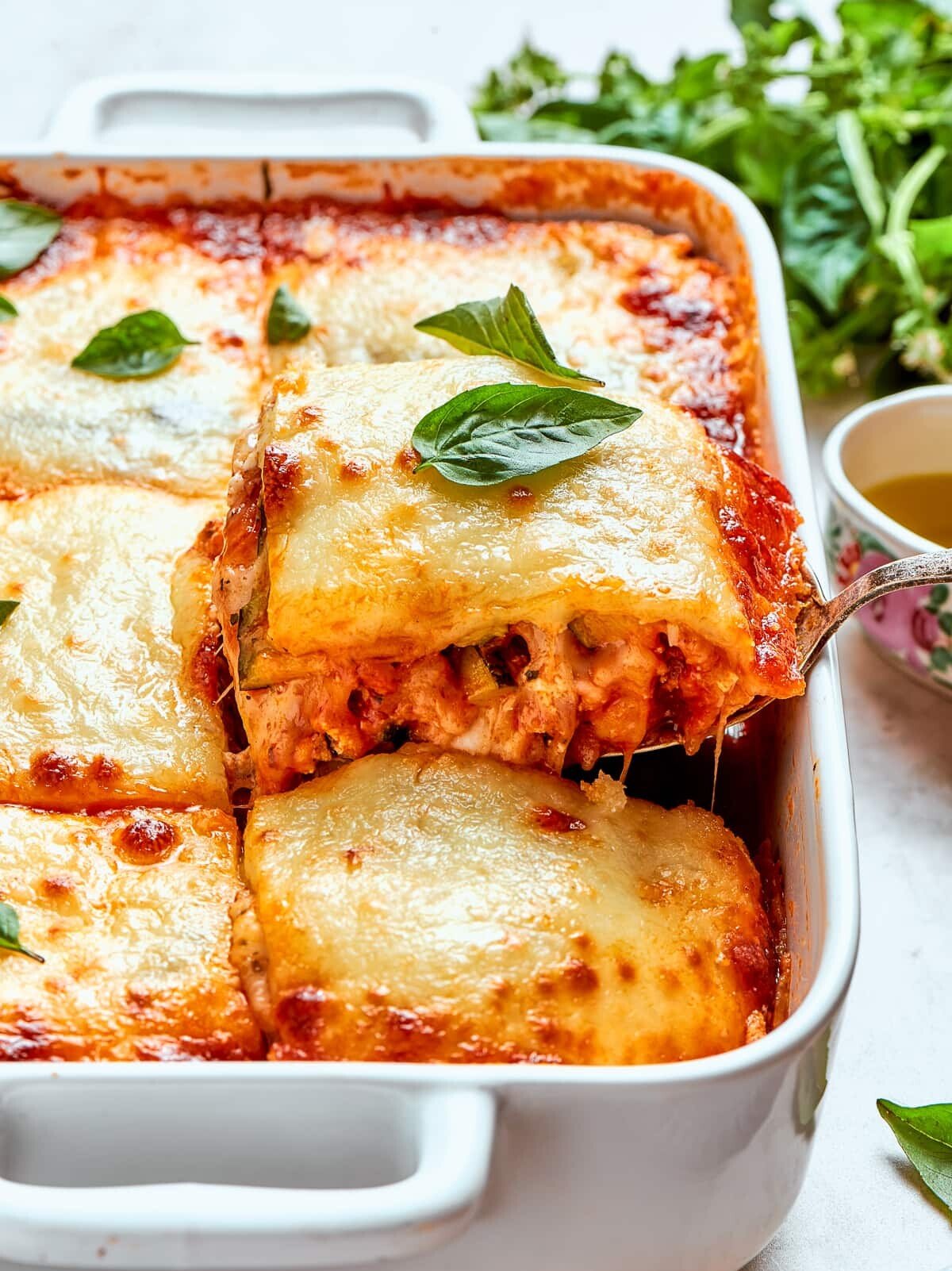 A slice being lifted from the pan, cheese stretching and layers holding together.