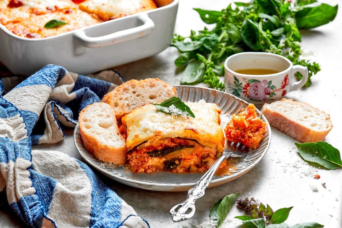 A slice of zucchini lasagna served neatly on a silver plate with visible layers.
