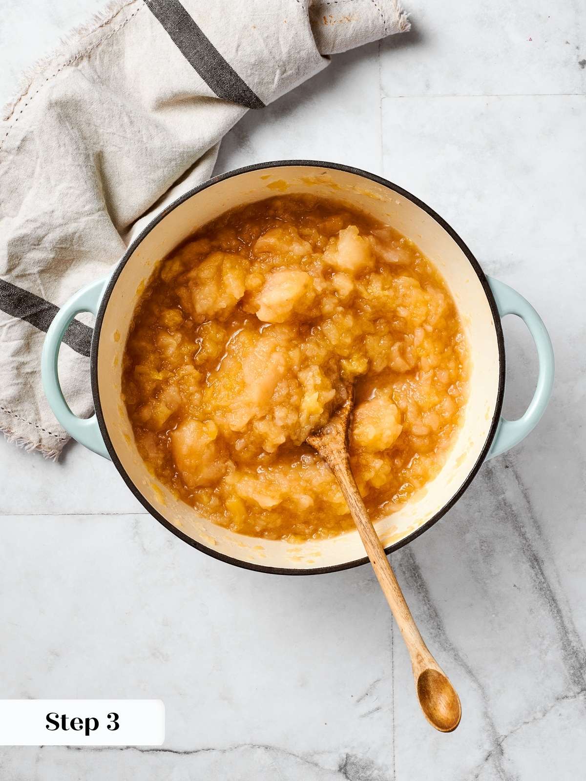Cook apples with water in a large pot, showing the process for homemade applesauce.