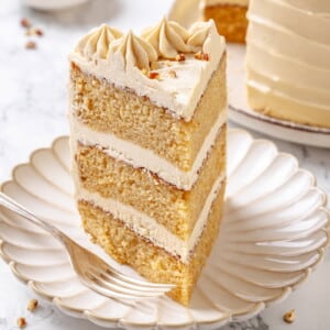Slice of maple cake on a white plate with layers visible.