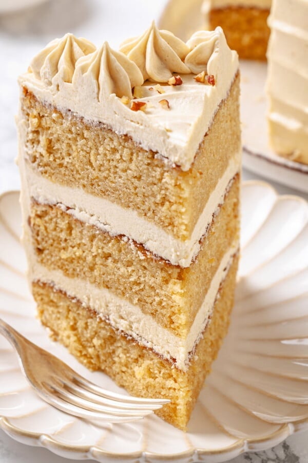 Slice of maple cake on a white plate with layers visible.