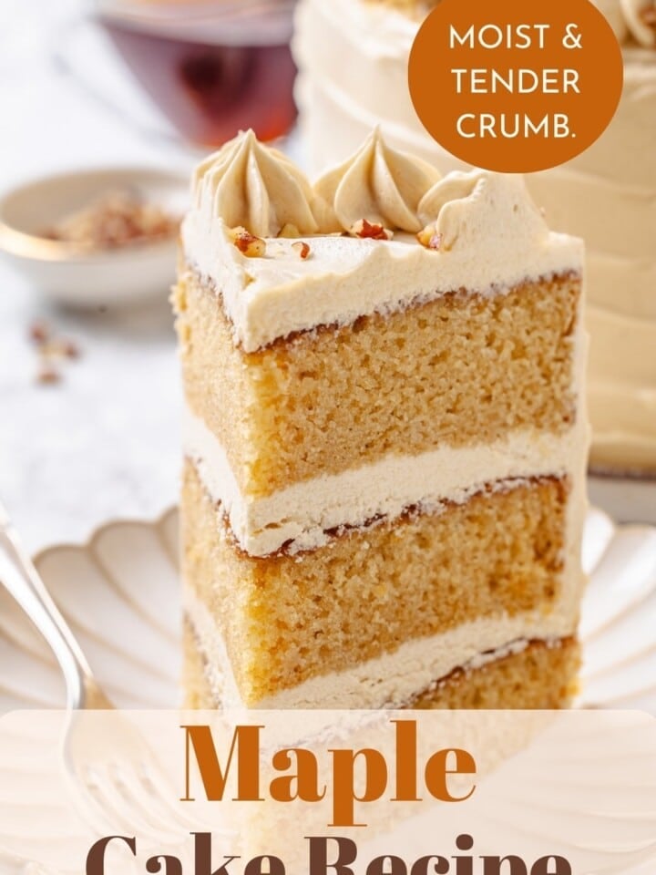 Fork resting beside maple cake slice, layers highlighted with thick, creamy maple frosting.