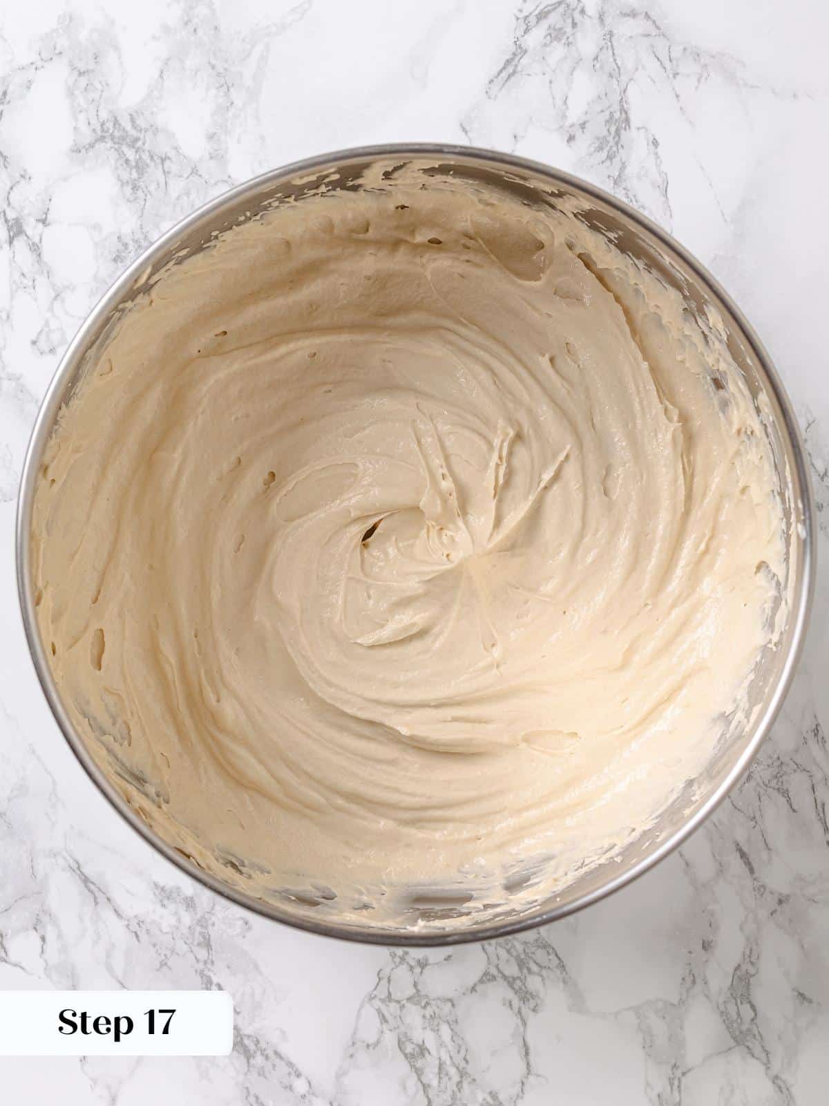Finished maple frosting in bowl, light texture ready for spreading over cake layers.