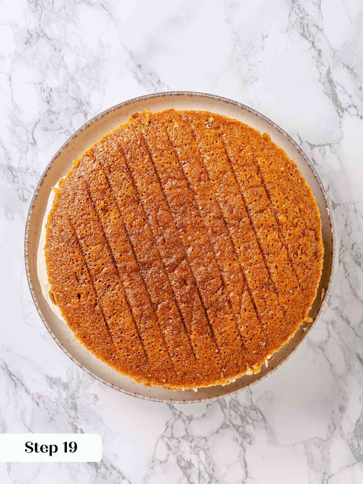Second cake layer added on top of frosting, ready to be spread and smoothed.