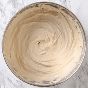 Maple frosting finished in a mixing bowl, fluffy texture with visible swirls.