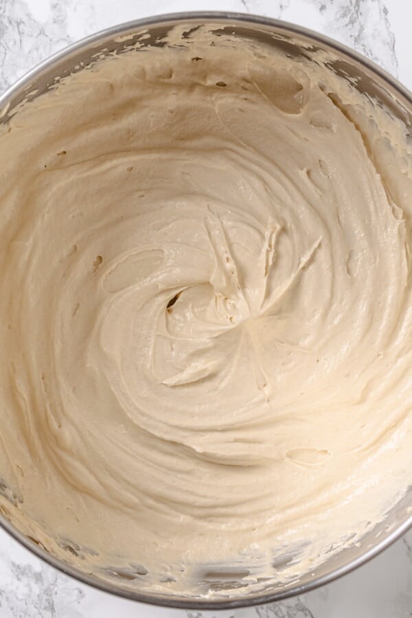 Maple frosting finished in a mixing bowl, fluffy texture with visible swirls.