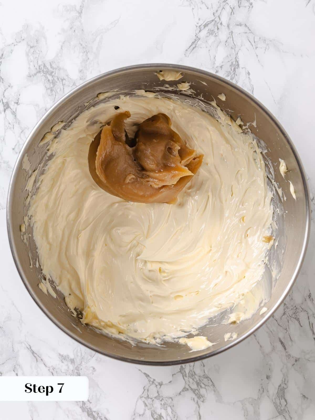 Maple mixture added spoonful by spoonful to whipped butter in stand mixer bowl.
