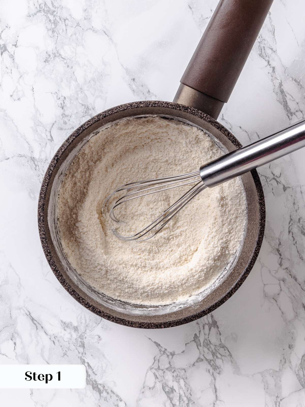 Dry flour, sugar, and salt stirred together in a saucepan to begin frosting base.