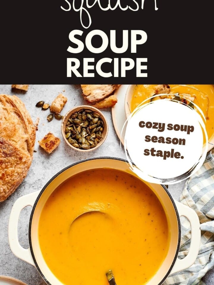 Warm vegetable broth-based squash soup photographed in a rustic kitchen setting with bread slices nearby.