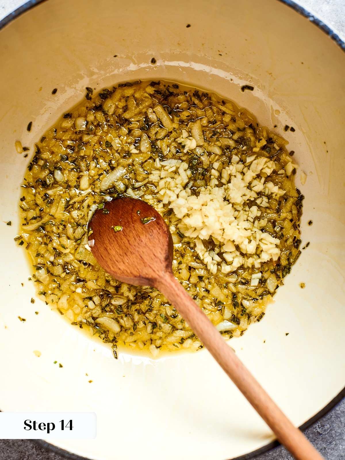 Fresh minced garlic added to sautéed onions and herbs in hot oil.