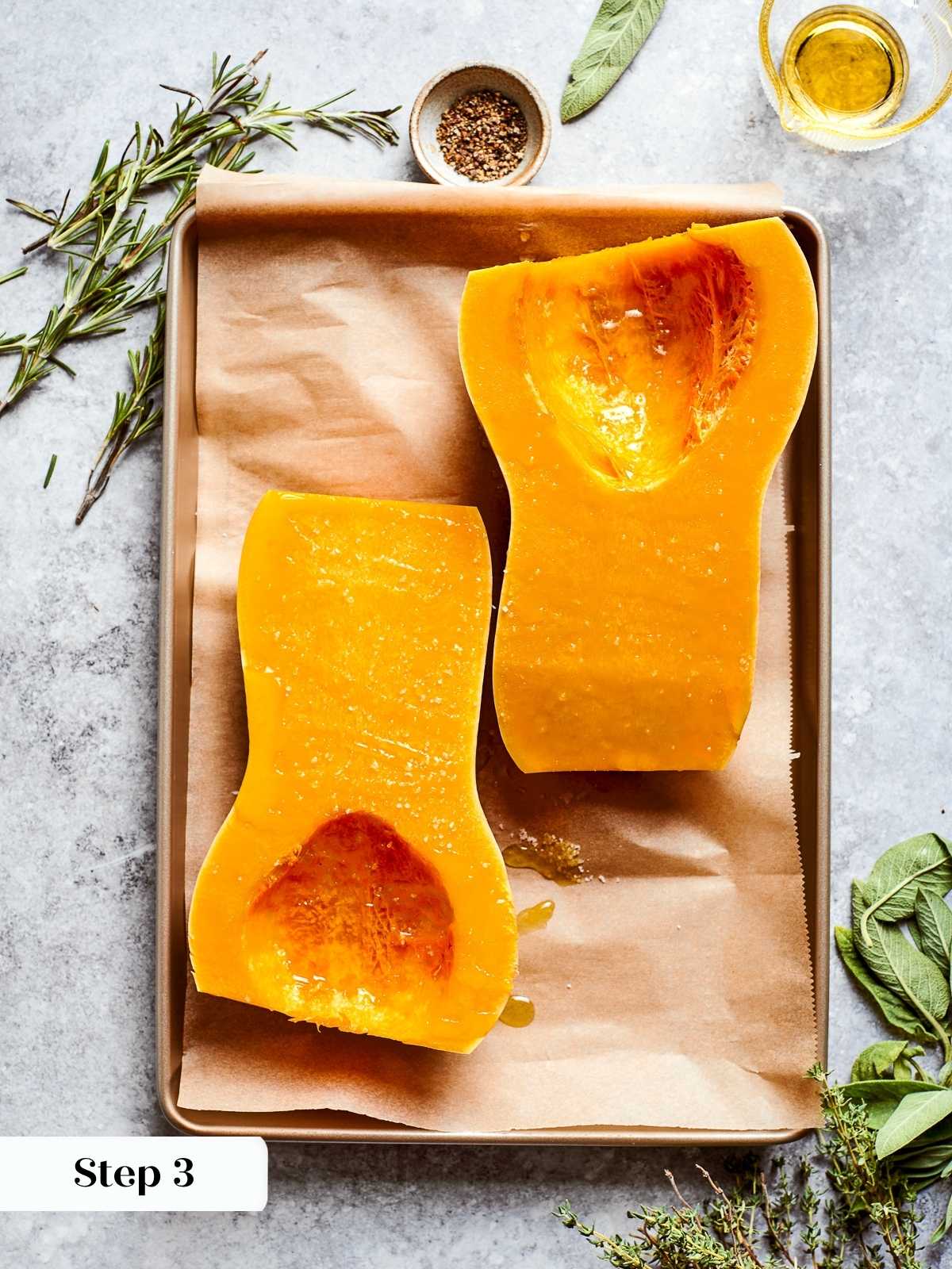 Butternut squash cut in half with seeds scooped out, prepped for roasting.