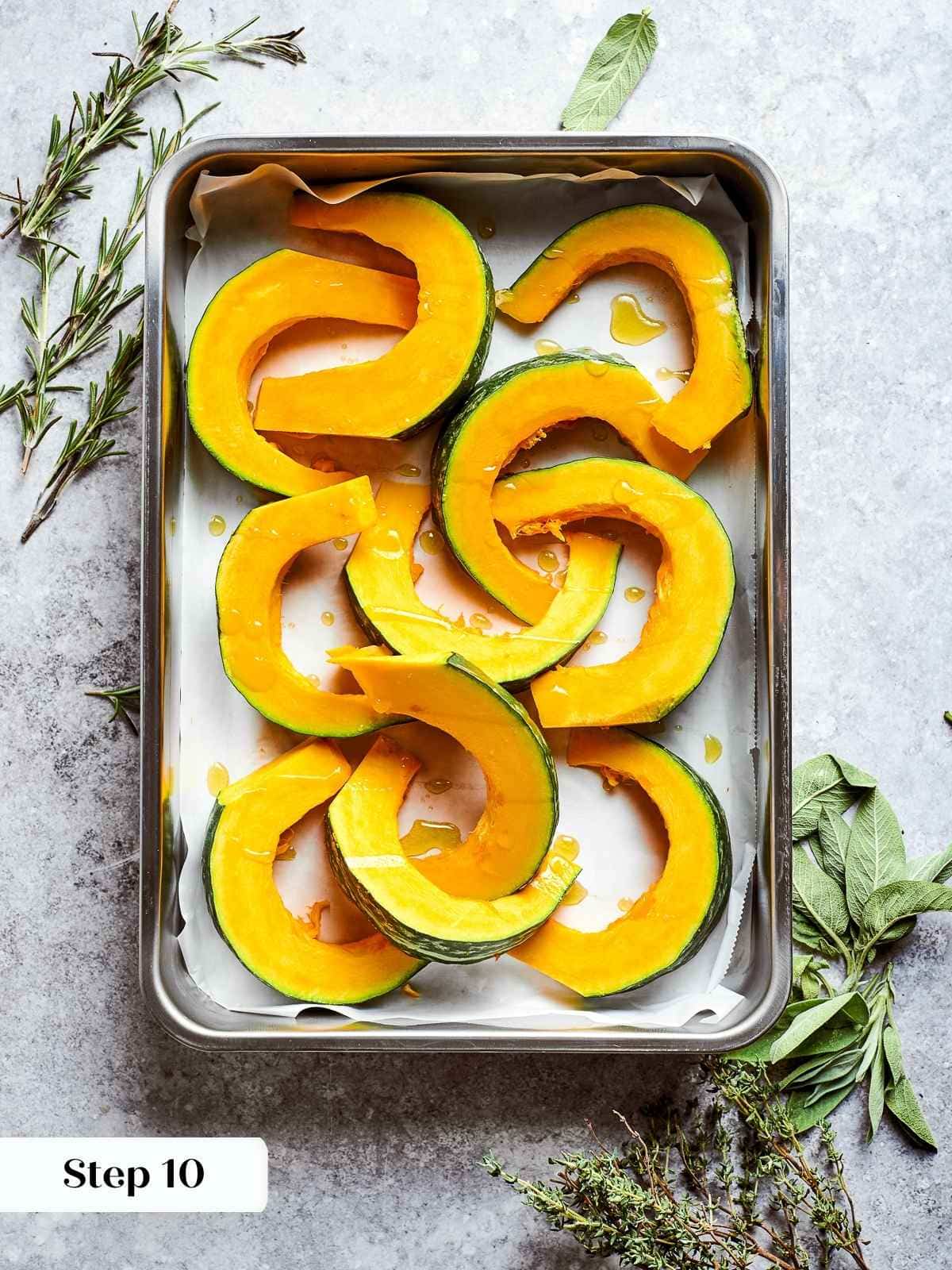 Fresh kabocha squash chunks arranged on baking sheet before roasting.