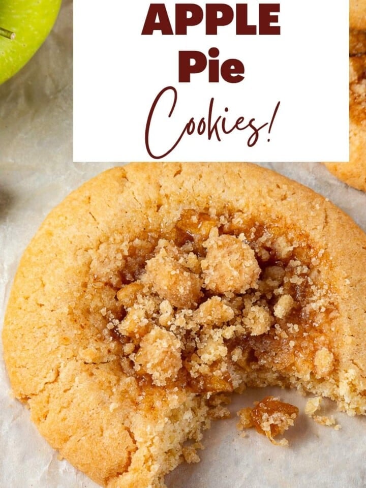Golden brown apple pie cookies arranged on parchment paper with bits of cinnamon apple peeking through.