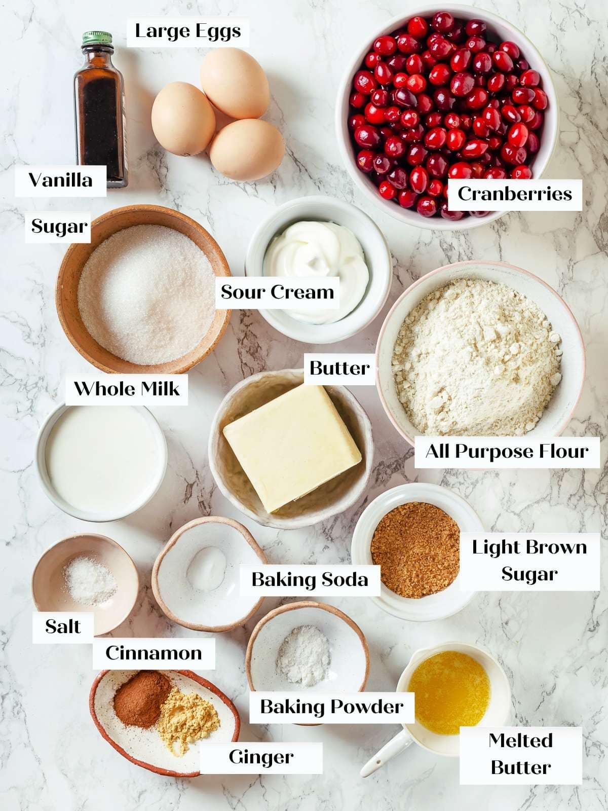 Measured cranberry cake ingredients arranged neatly on a white countertop ready for baking.