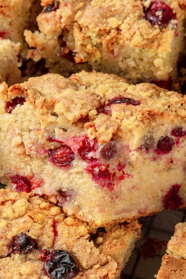 Slices of cranberry cake showing crisp brown sugar streusel over tender cranberry-filled crumb.