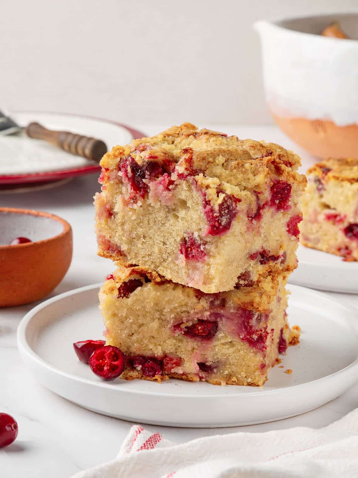 Two slices of cranberry cake stacked to show layers of tart berries and soft texture.