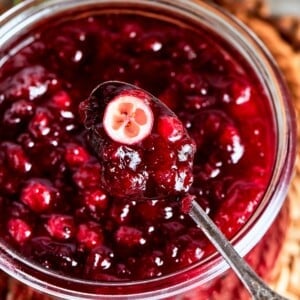 A halved cranberry in sauce showing its tart interior and vibrant red hue.