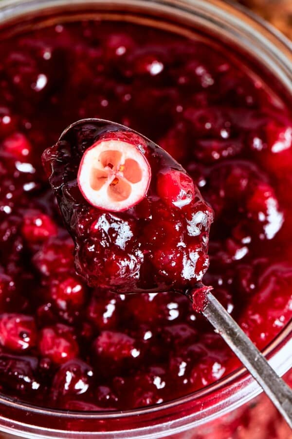A halved cranberry in sauce showing its tart interior and vibrant red hue.