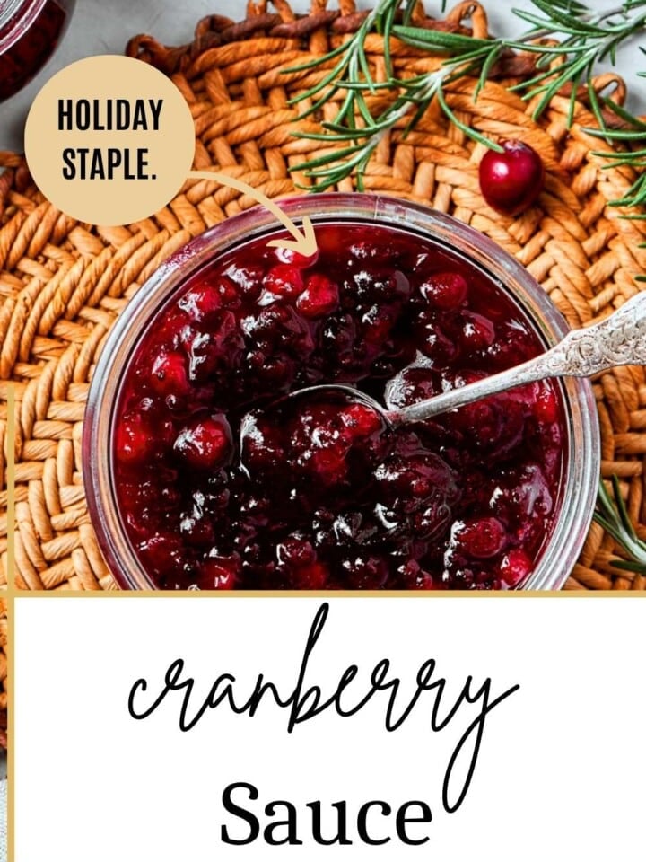 Spoonful of bright red cranberry sauce with apple pieces and spices on a holiday dinner table.