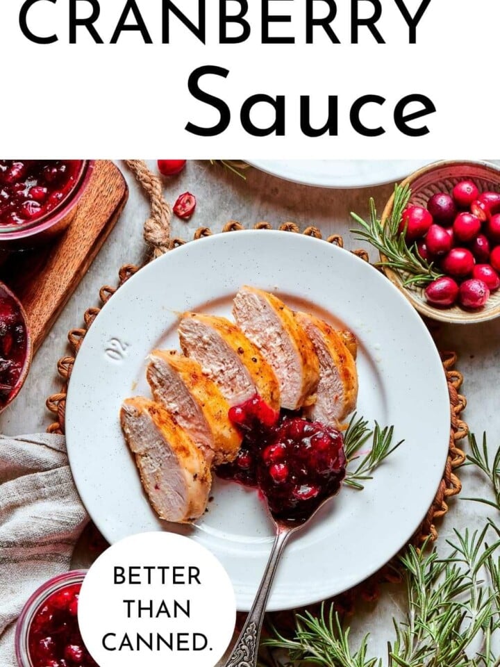 Fresh cranberry sauce simmered with apple cider, cinnamon, and cardamom served on a white plate for holidays.