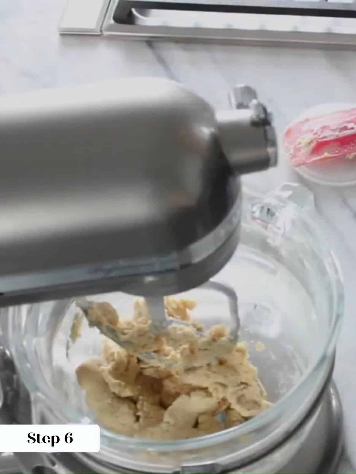 Flour mixture added to linzer cookie dough, making a prepared dough in mixing bowl.