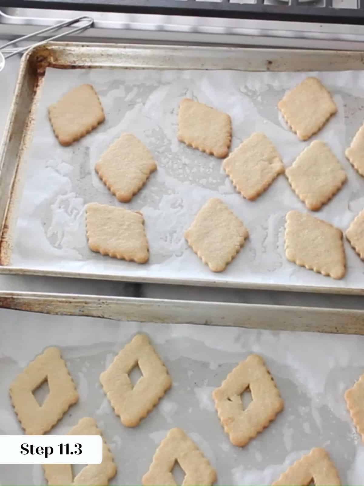 Golden Linzer cookie diamonds cooling on parchment paper after baking.