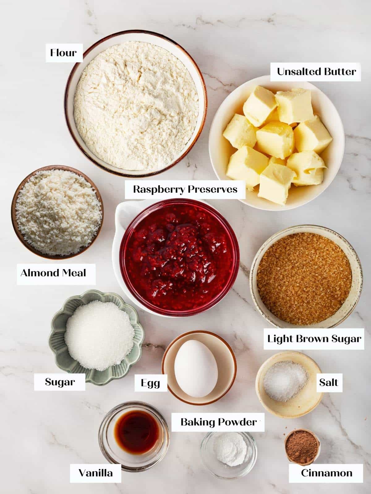 Measured Linzer cookie ingredients displayed in bowls on a counter before mixing begins.