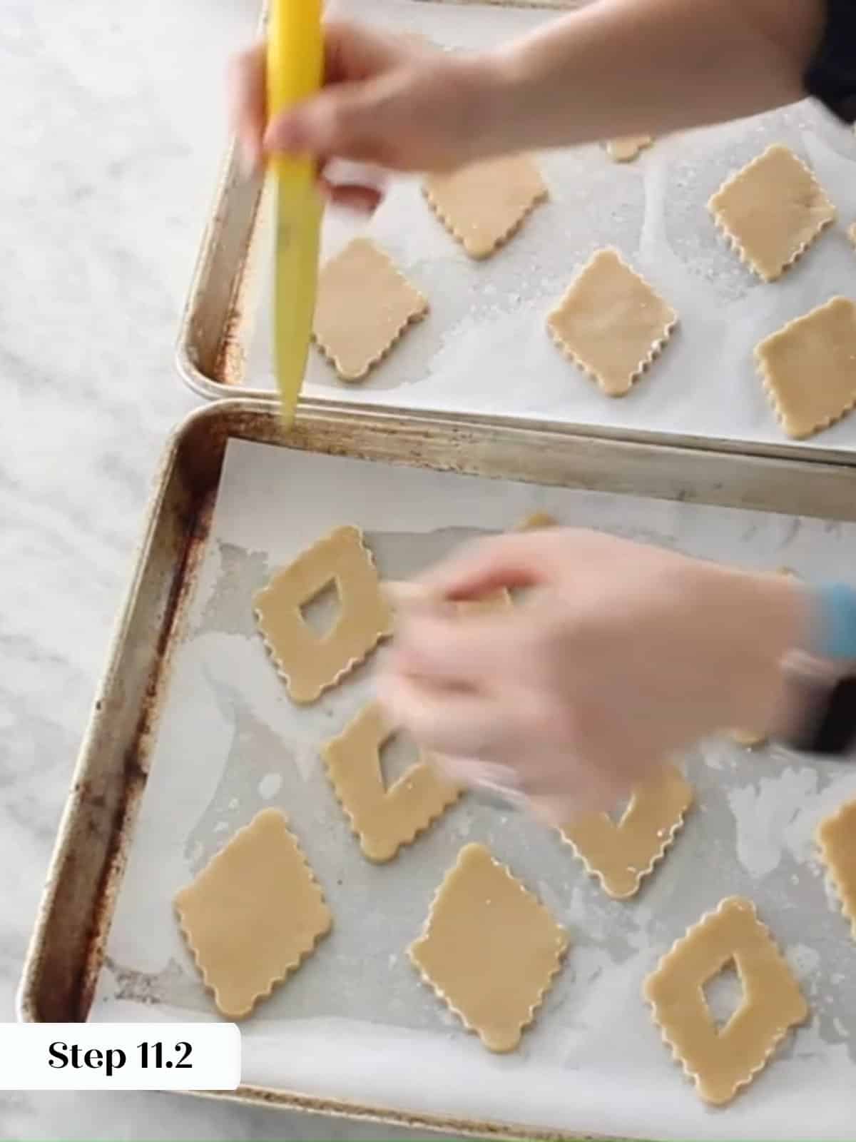 Unbaked Linzer cookies with small center cutouts arranged on parchment paper, ready for baking.