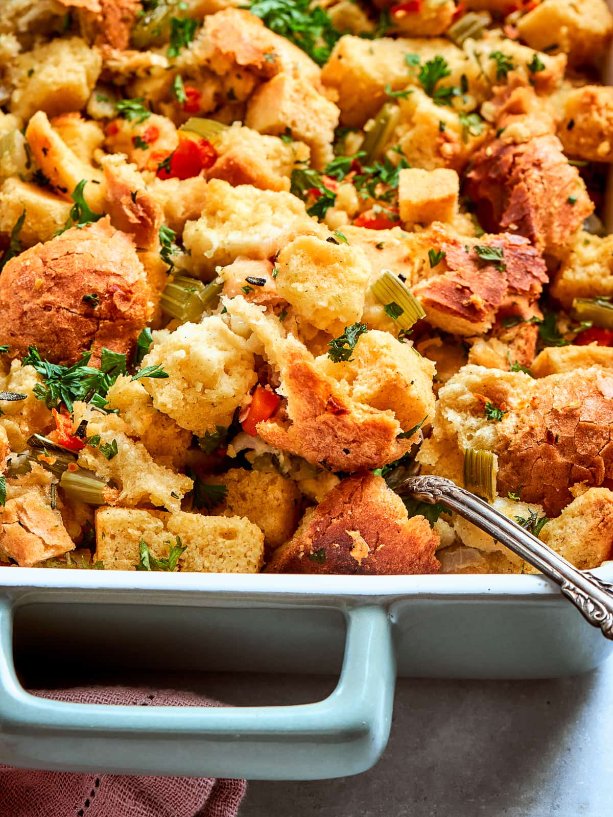 Garnished cornbread dressing topped with chopped herbs ready to serve for Thanksgiving dinner.