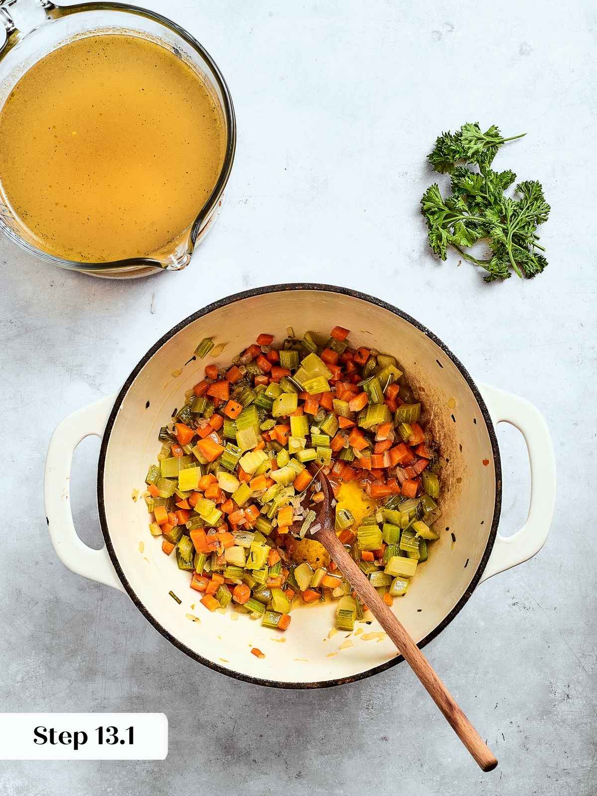 Skillet filled with sautéed onions, celery, and herbs being cooked for Southern cornbread dressing.