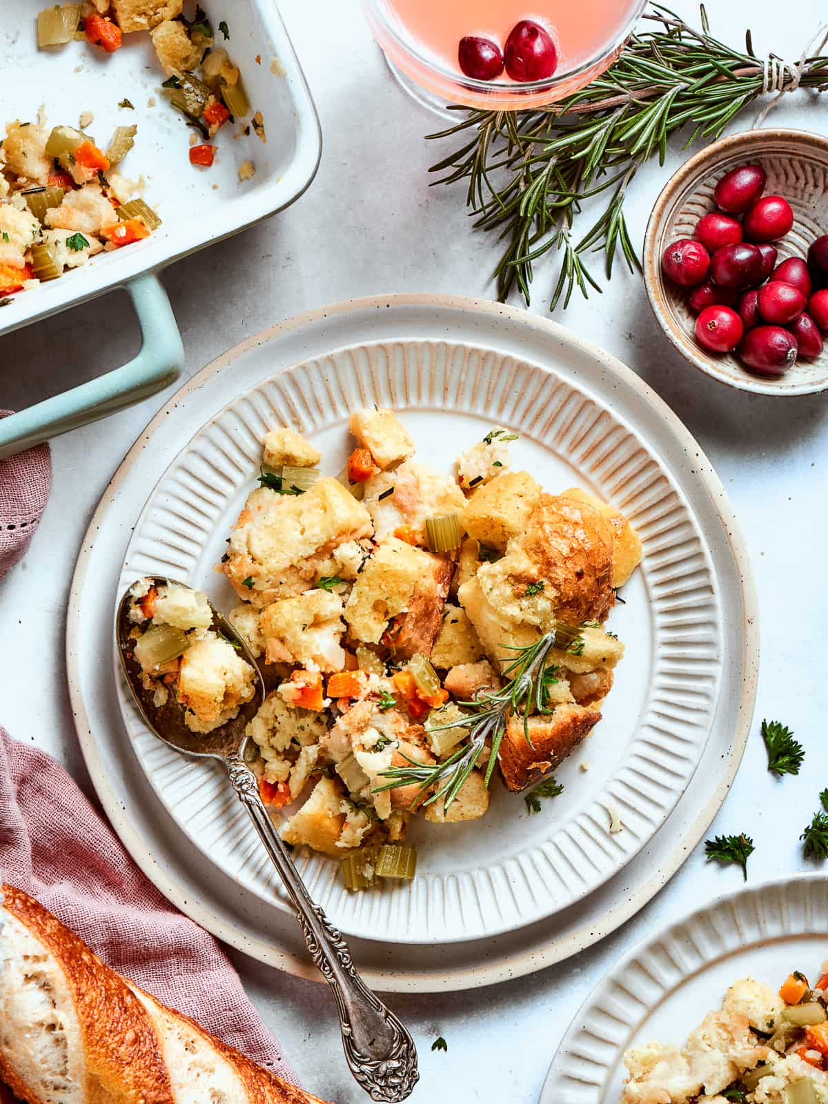 Portion of cornbread dressing on a white plate showing tender interior and crispy top.