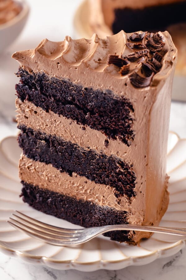 Chocolate cake slice highlighting smooth buttercream between moist layers.