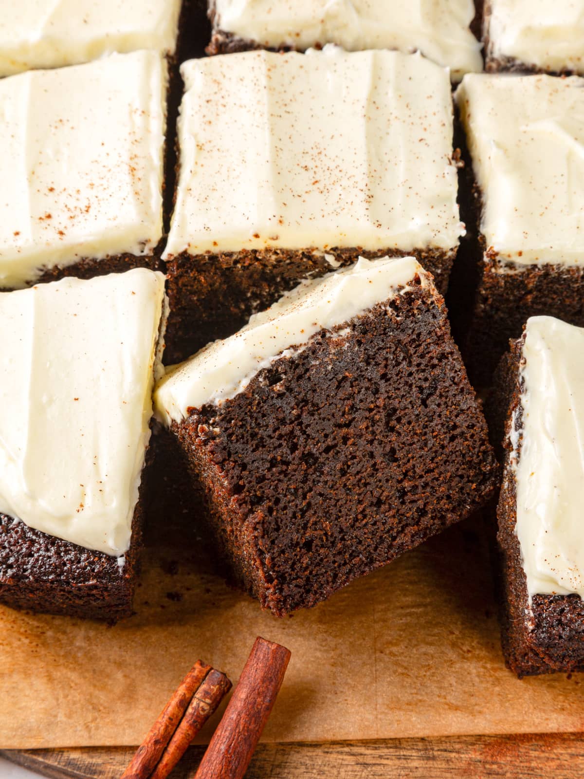 Several gingerbread cake pieces with cinnamon sticks reinforcing the cozy holiday flavor profile.