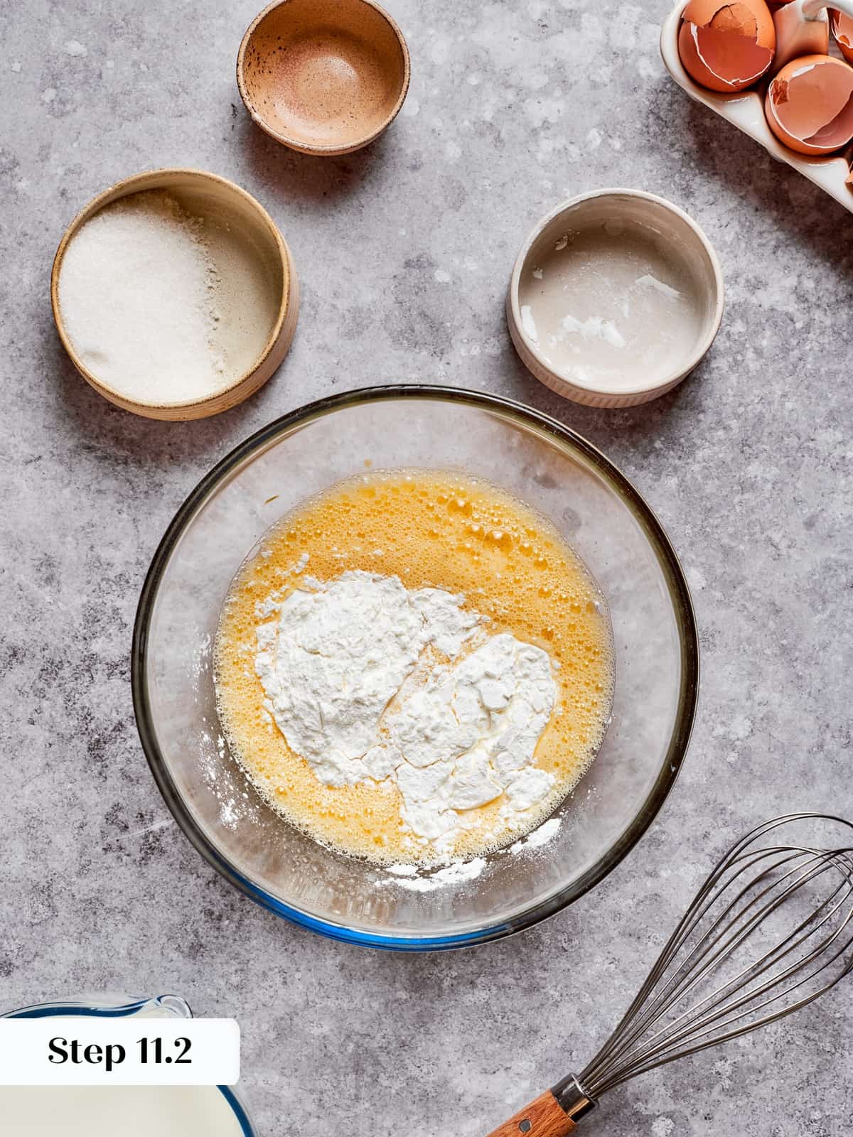 Cornstarch being whisked into the egg mixture to prepare the pastry cream base.