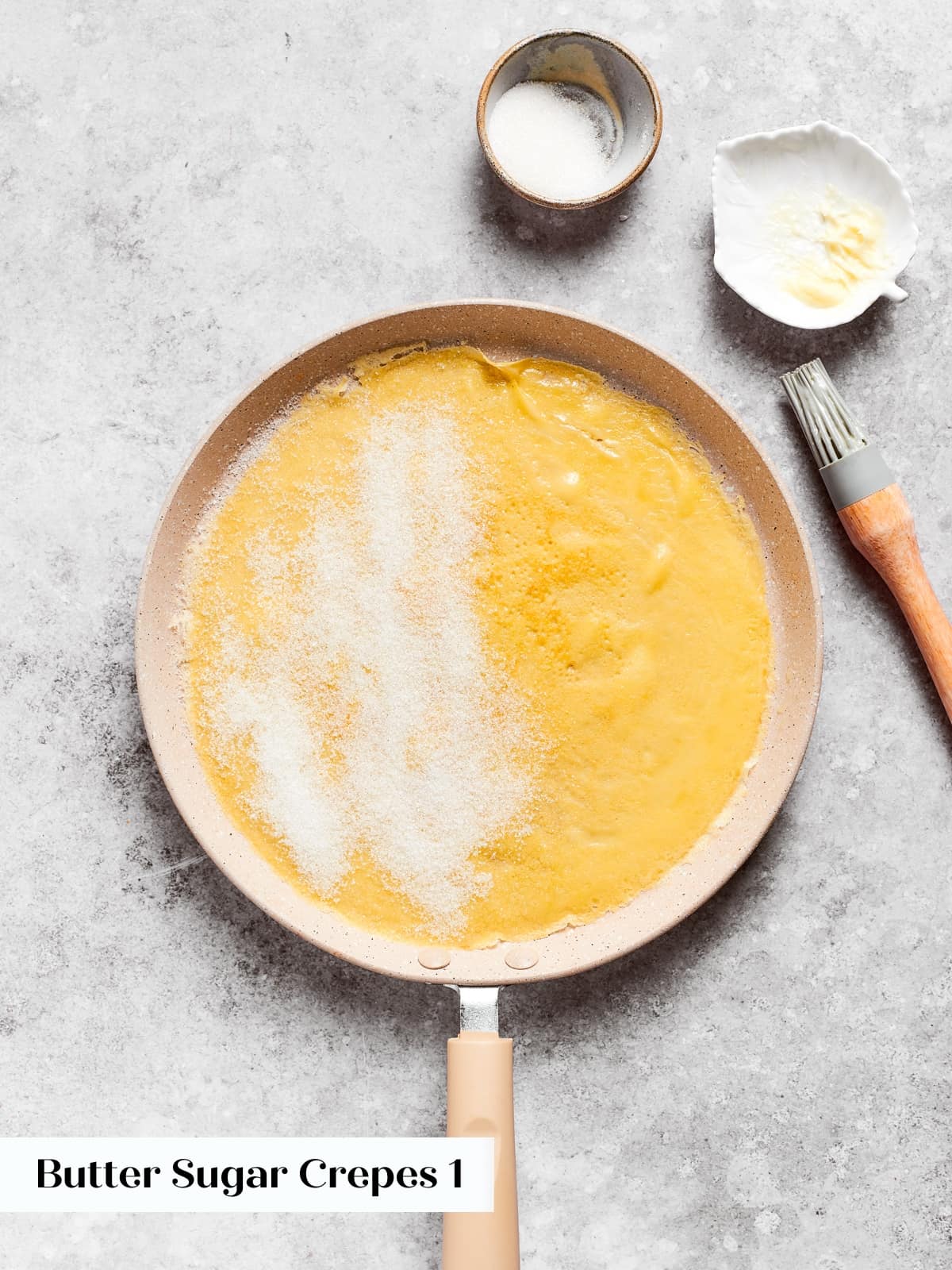 A warm crepe sprinkled on one side with sugar before folding in the pan.